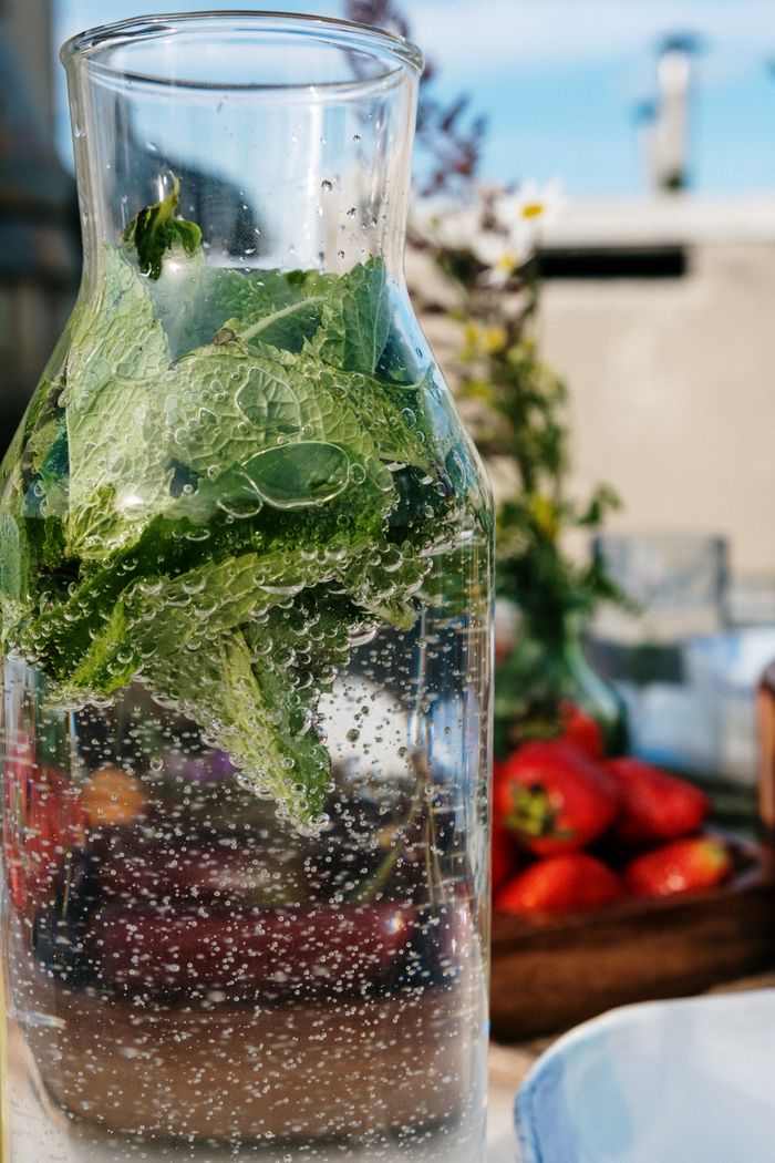 Infused water with mint leaves and strawberries, perfect for a refreshing summer brunch.